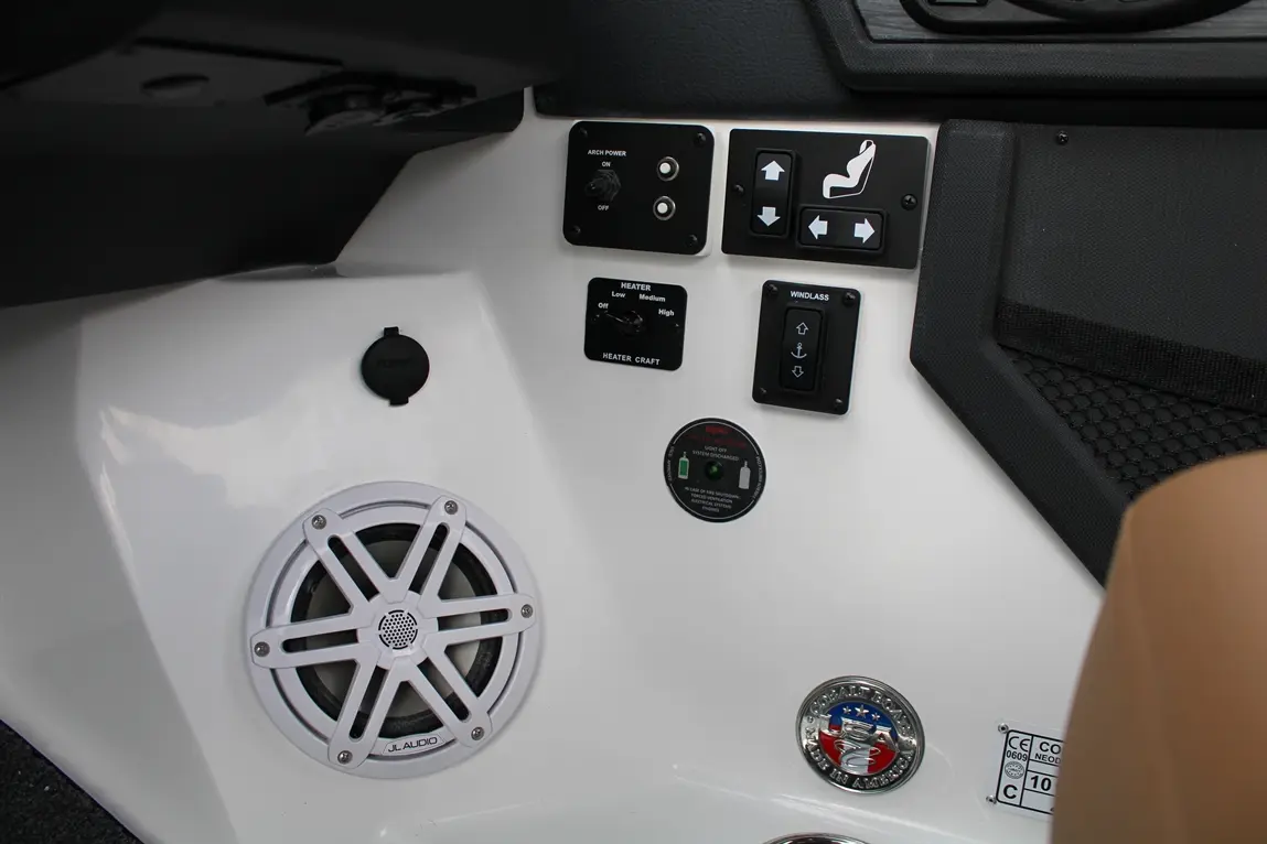 Control panel of a boat featuring speaker, heater settings, windlass controls, and various buttons on a white surface.